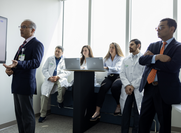 A group of health professionals meet about a consultation on laptops